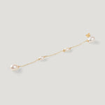 Single gold pearl chain earring laid diagonally, showing stud and dangling pearls.