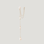 Single gold pearl chain earring with ear cuff, hanging vertically on light background.
