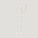 Pair of gold pearl chain earrings hanging straight, one with an ear cuff attached.