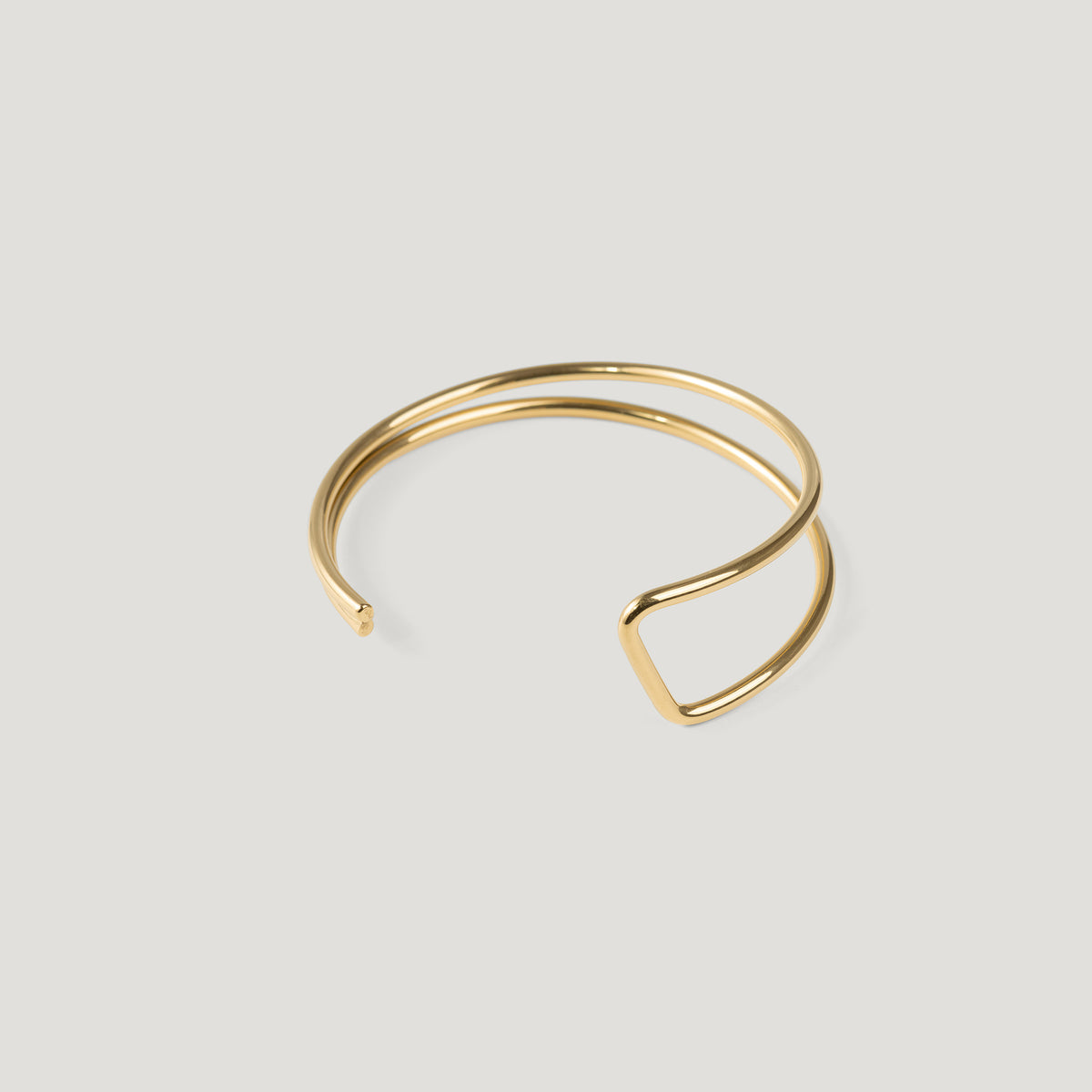 Gold cuff bangle with a double wire band, angular kink visible on the right side.