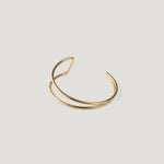 Gold cuff bangle with a double wire band, shown face-on in a fuller oval shape.