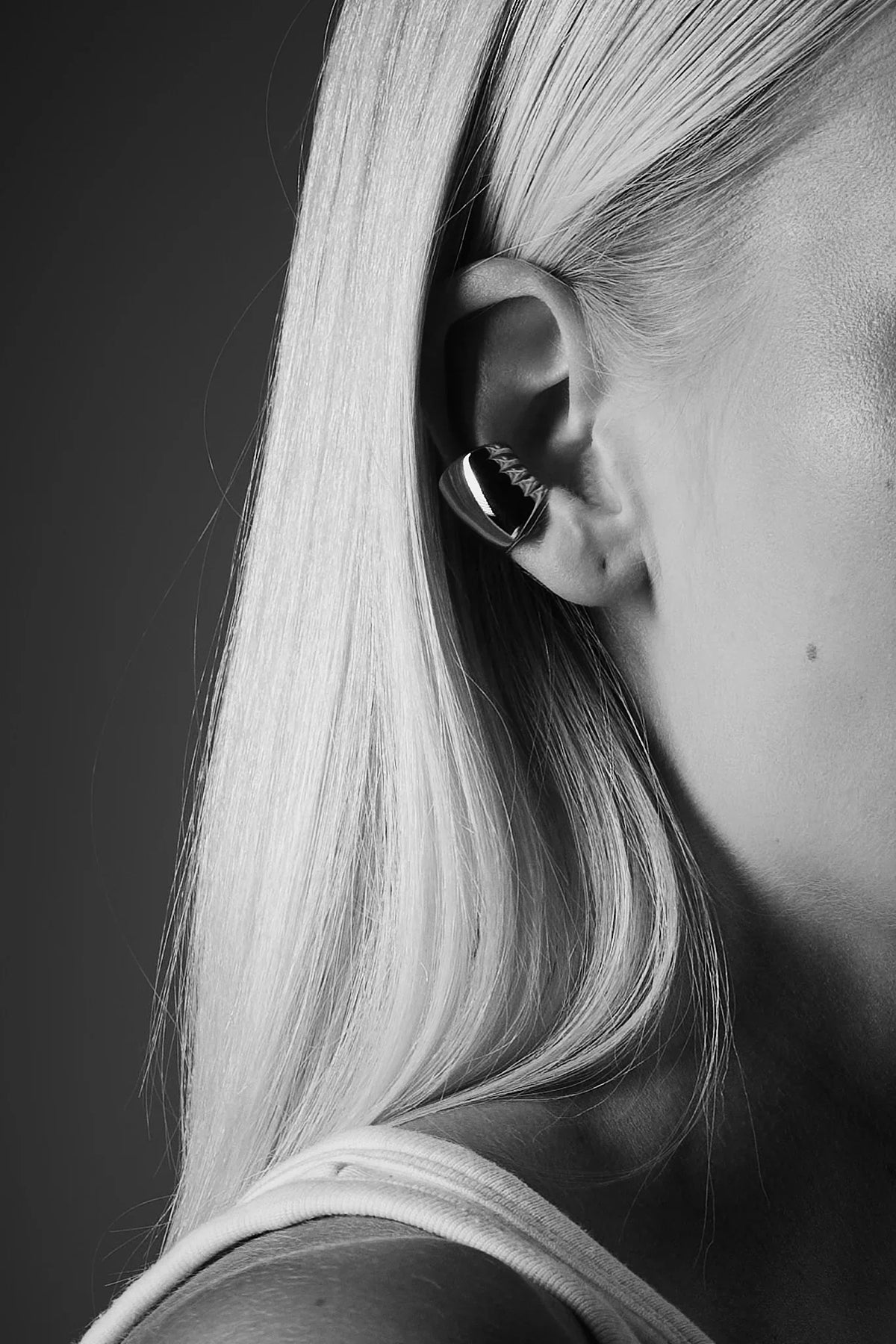 Minimalist silver ear cuff on ear, sleek contemporary jewelry, side profile