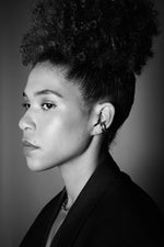 Profile of woman wearing hoop earrings and necklace, monochrome portrait, jewellery focus