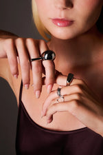 Woman wearing silver statement rings on fingers, close-up jewelry shot