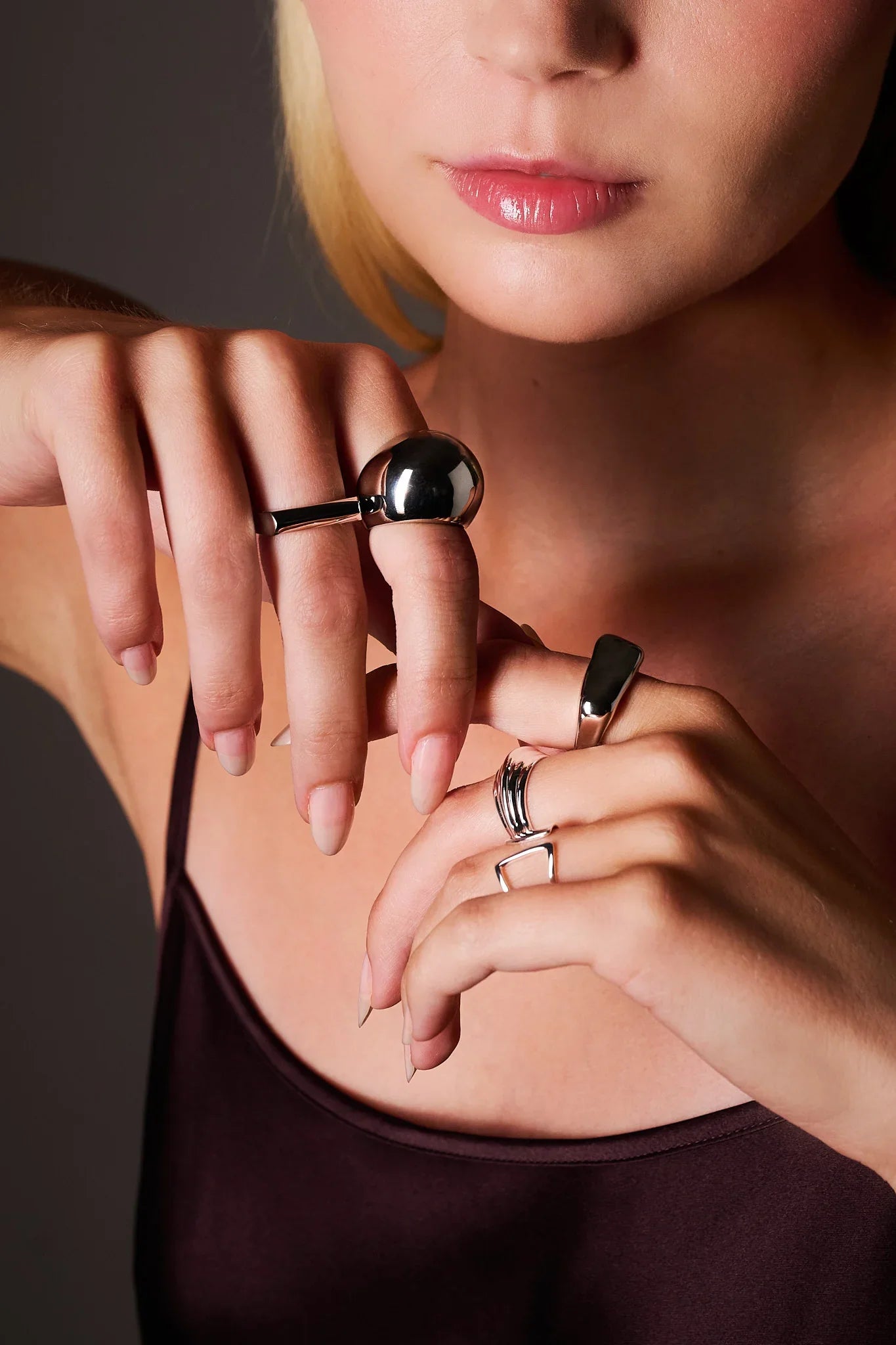 Woman wearing silver statement rings on fingers, close-up jewelry shot