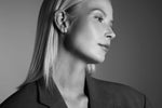 Woman wearing modern silver hoop earrings and ear cuff, minimalist style