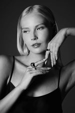 Woman wearing bold silver rings and black camisole in monochrome studio portrait