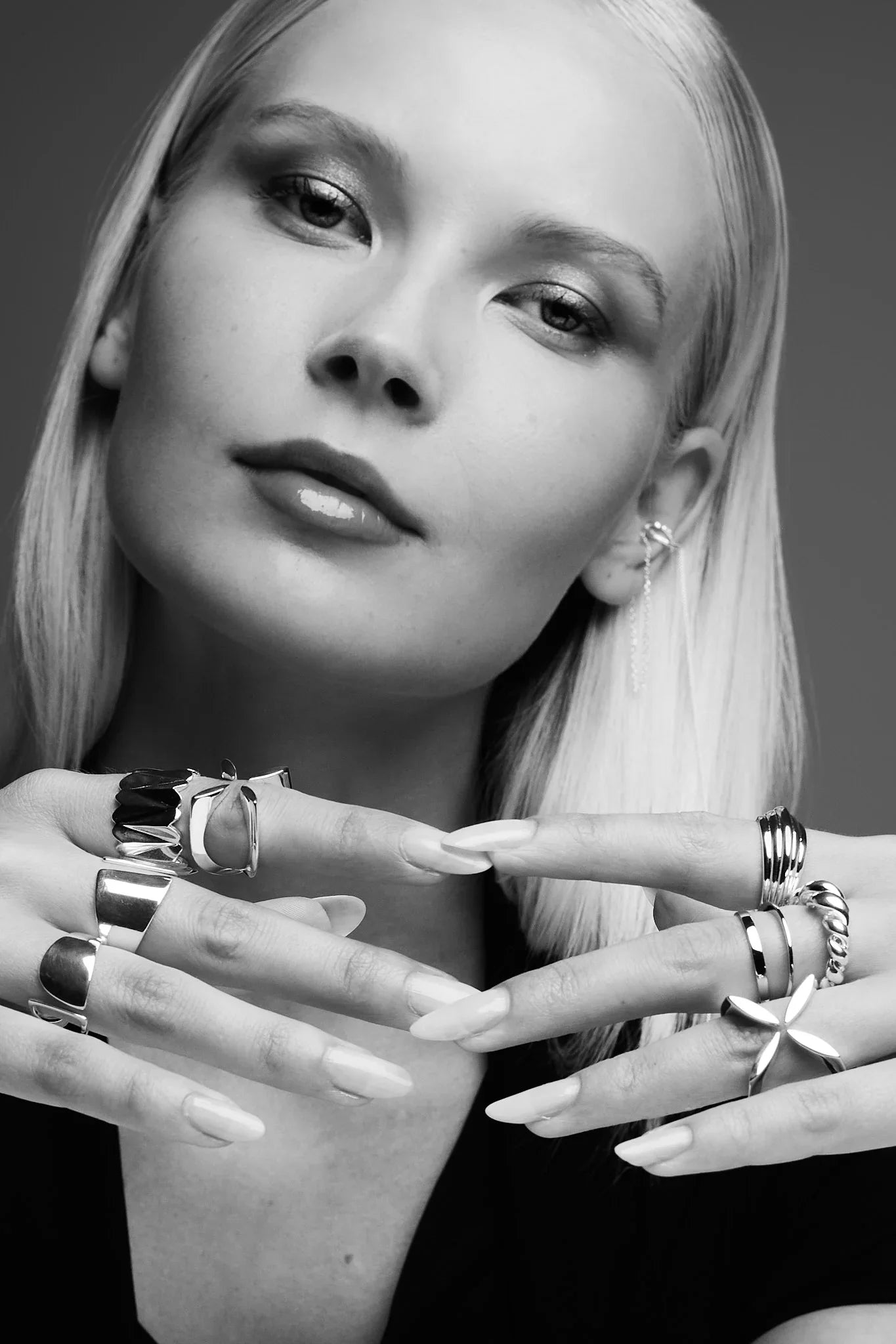 Woman with multiple silver rings and an ear cuff, modern jewelry close-up