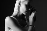 Black and white photo of woman wearing minimalist bangle bracelet and hoop earring
