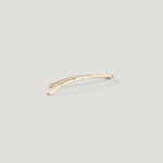 Single gold curved bar ear climber with a hammered texture, close-up on light background.