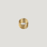 Gold statement ring made of tightly stacked wire coils, front view on light background.
