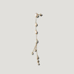 Single gold pearl drop earring hanging straight down, freshwater pearls along chain.