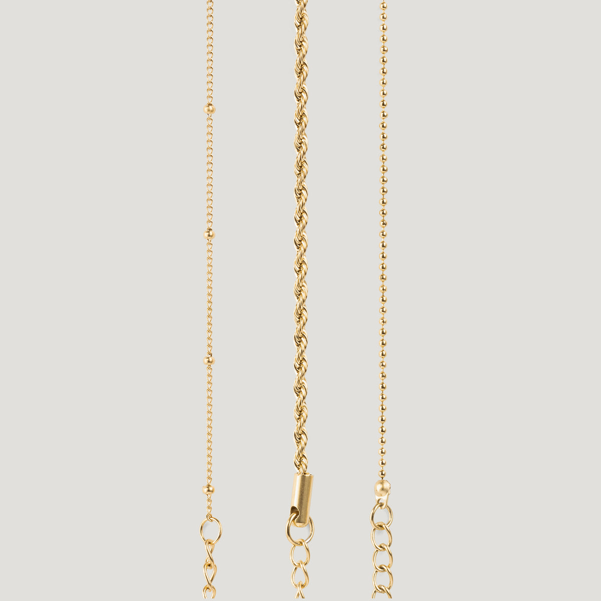 Gold bracelet set with beaded, twisted rope and beaded chain strands on light background.
