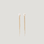 Pair of gold earrings with freshwater pearl studs and dangling chain tassels on light background