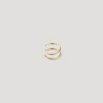 Single gold double-band ear cuff, viewed from a different angle on light background.