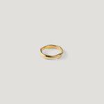 Single wide gold ring with a smooth organic wavy band, top-down, shown alone.