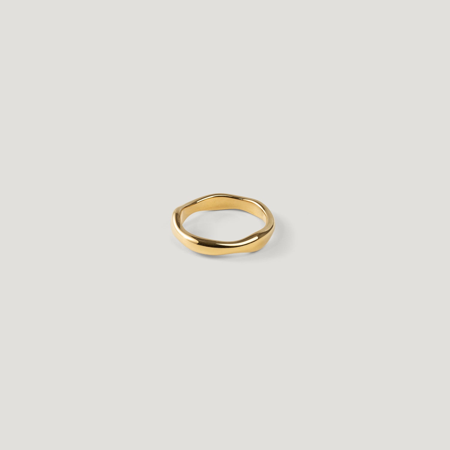 Single wide gold ring with a smooth organic wavy band, top-down, shown alone.
