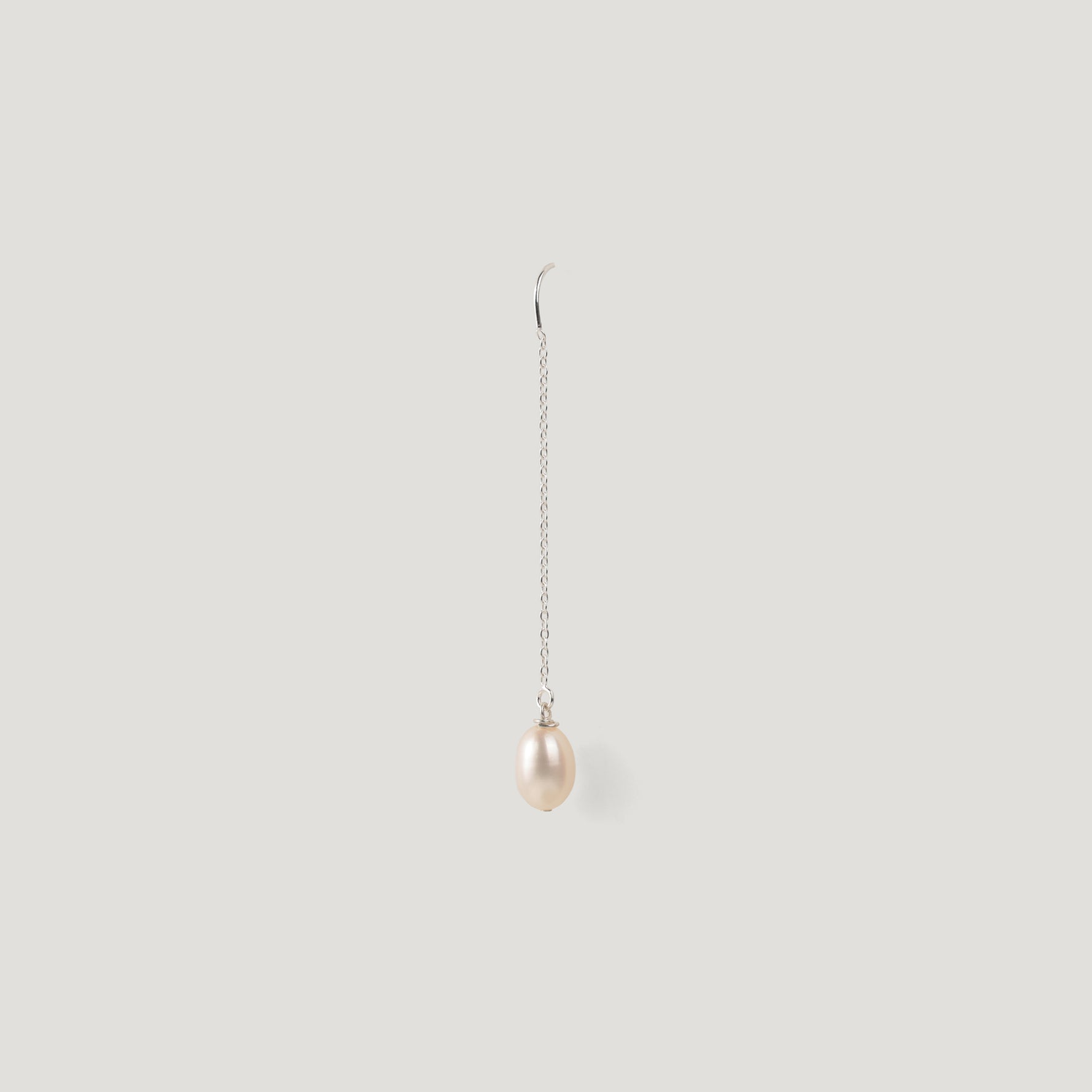 Single silver thread earring with a pearl drop, hanging vertically on light background.