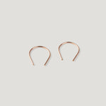 Pair of small rose gold thread earrings, a rounded arch shape on light background.