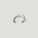 Single silver wire hoop earring laid flat, viewed from above on light background.