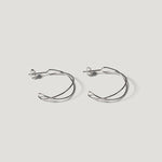 Pair of silver open wire hoop earrings with a twisted double-wire design, on light background.