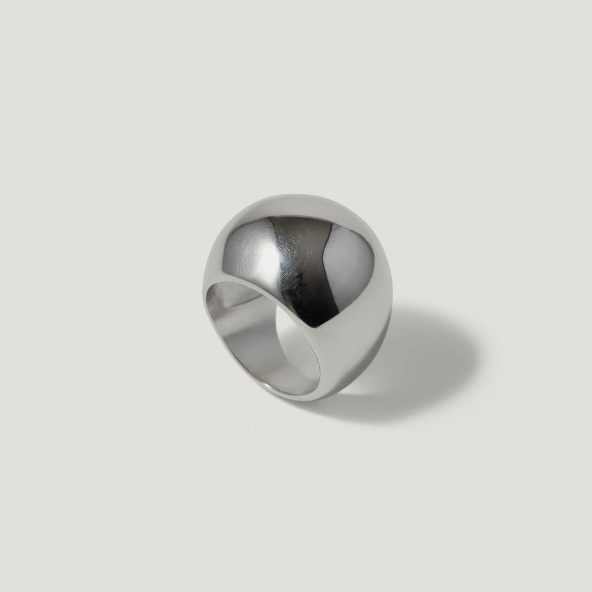 Bold wide dome silver ring on light background, minimalist modern jewelry