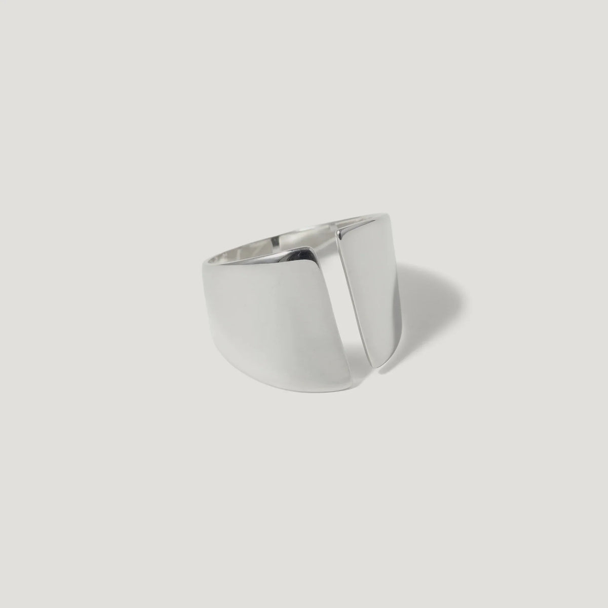 Modern geometric silver ring with open split design on white background