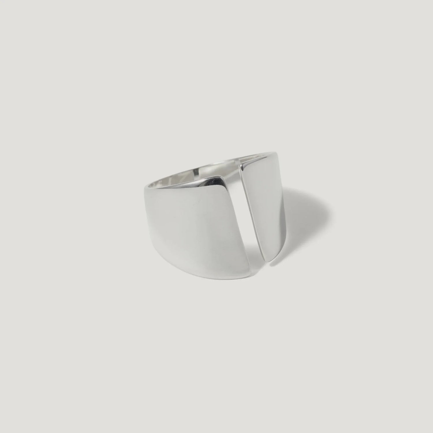 Modern geometric silver ring with open split design on white background