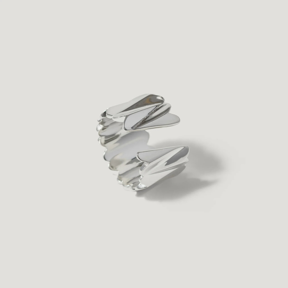 Modern silver ring with sculptural, angular design on a white background