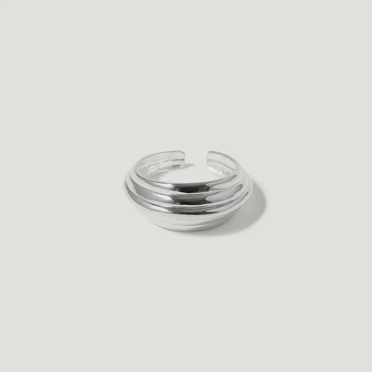Chunky silver dome ring with layered bands on a white background