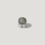 Textured silver ear cuff with grooved lines on a white background