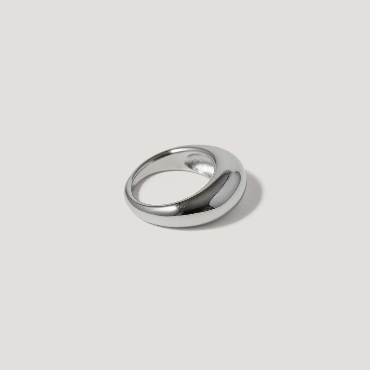 Polished silver dome ring with minimalist design on a light background