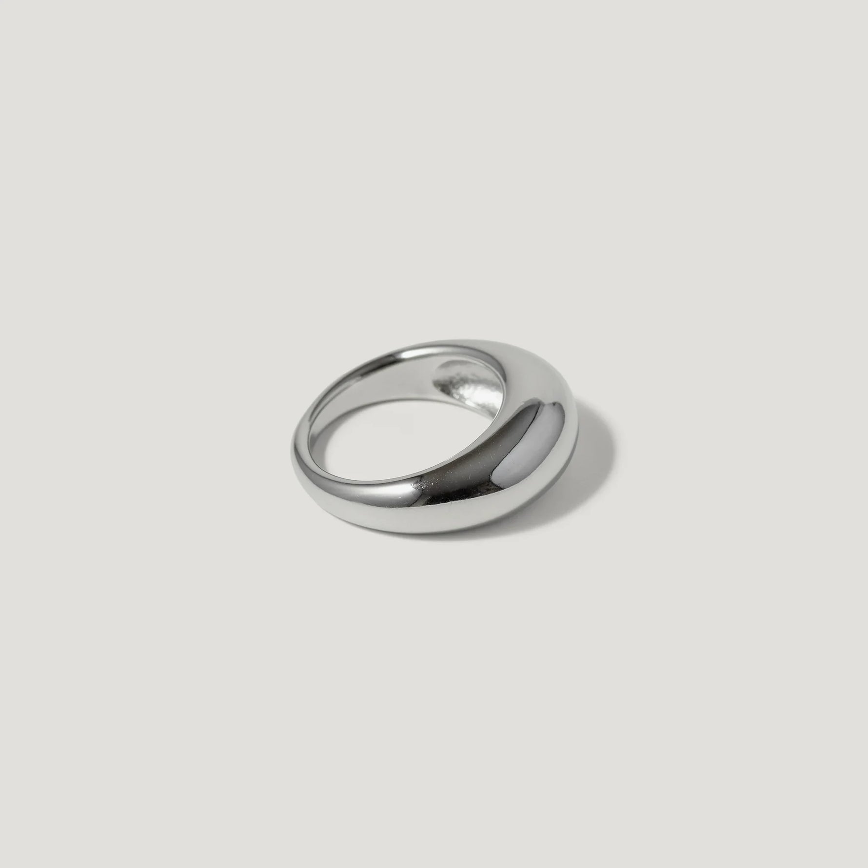 Polished silver dome ring with minimalist design on a light background