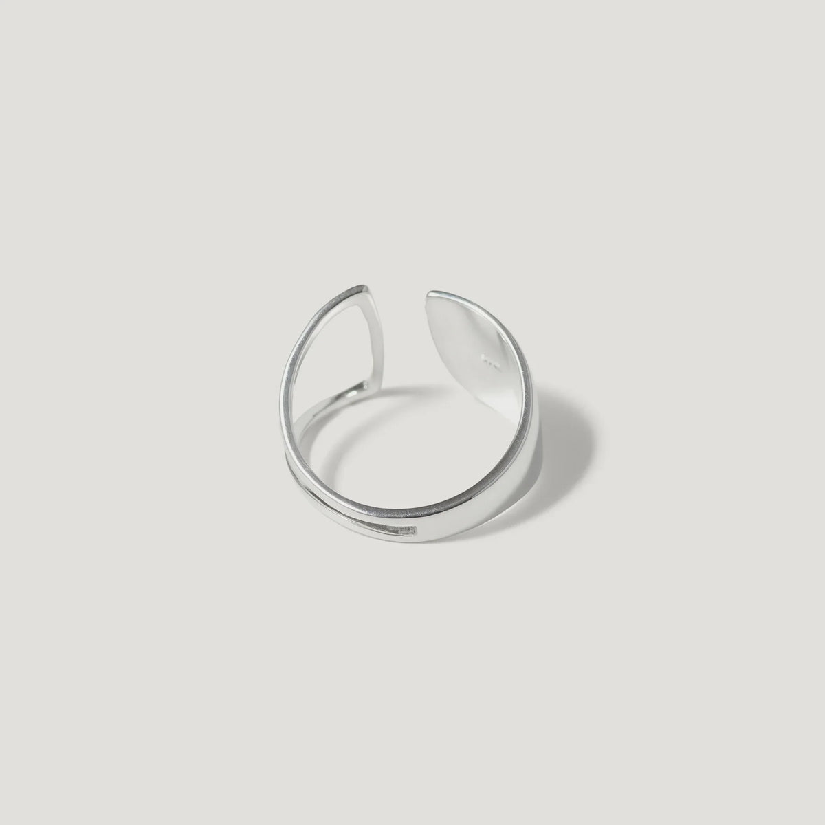 Minimalist open silver ring with smooth polished finish on white background