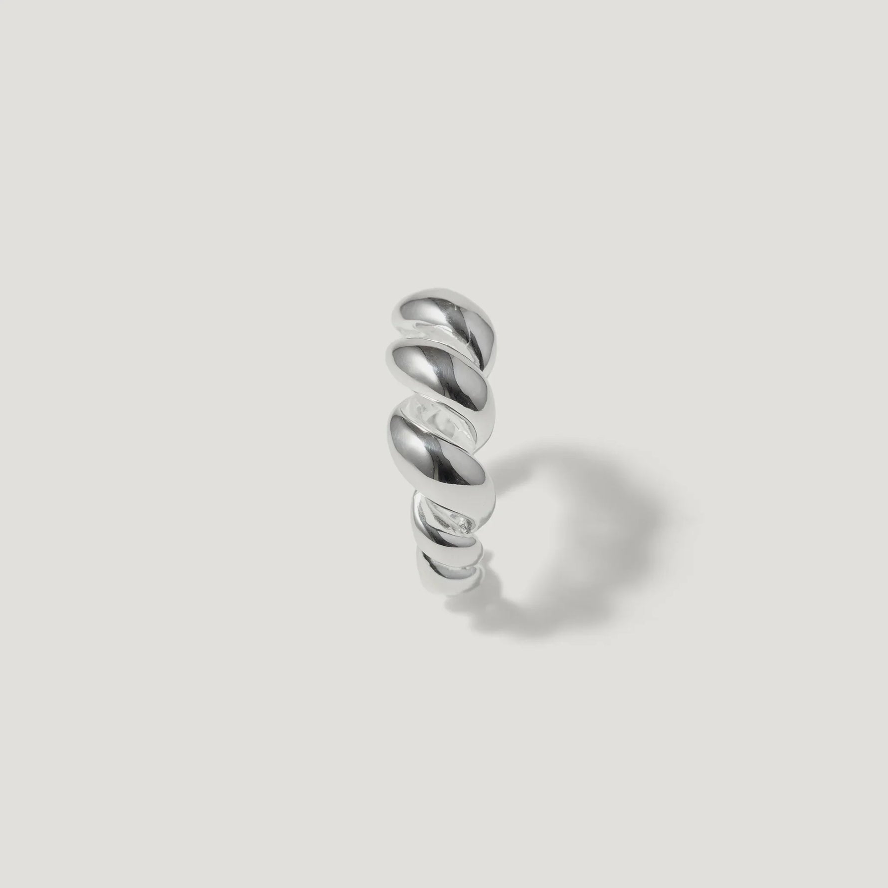 Sterling silver twisted band ring with polished finish on white background