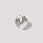 Minimalist open band silver ring on a plain light background