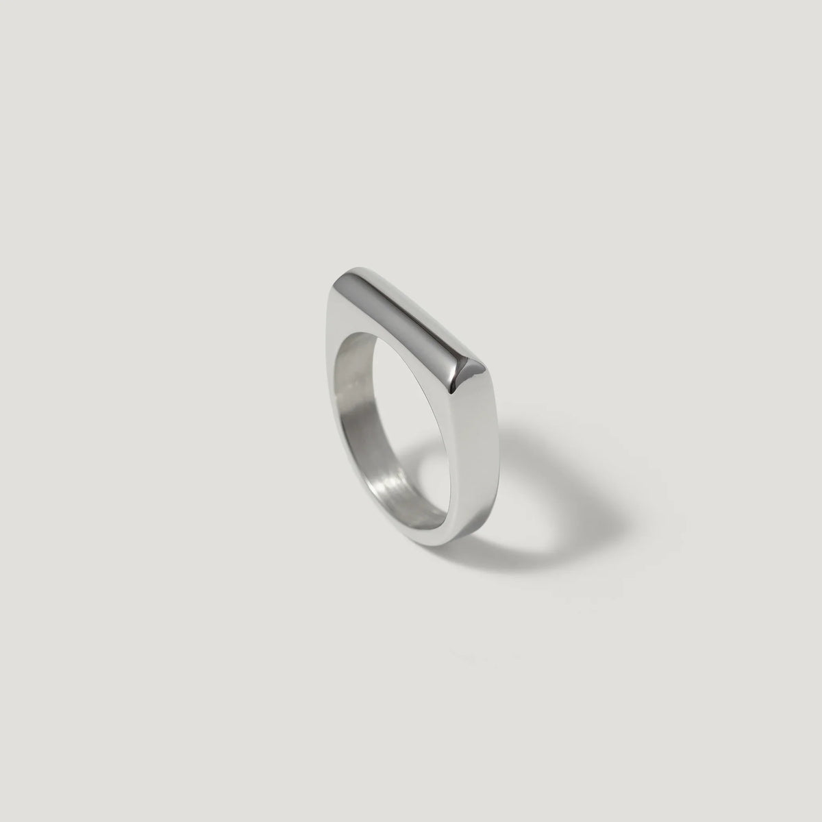 Minimalist silver geometric ring with flat top on white background