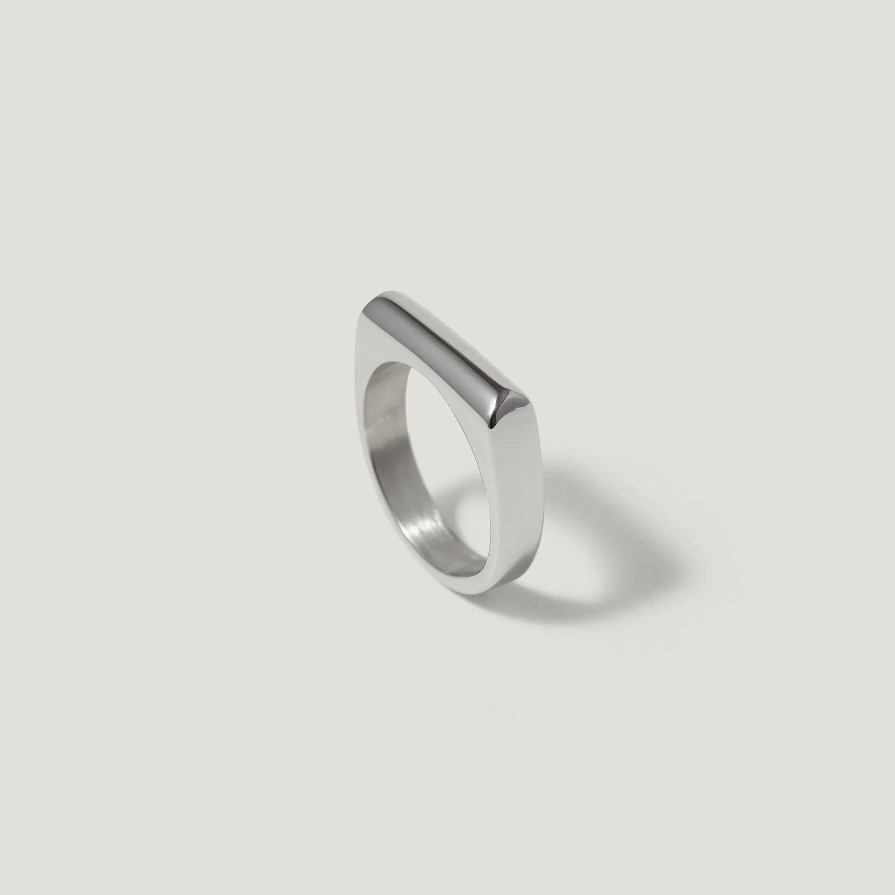 Minimalist silver geometric ring with flat top on white background