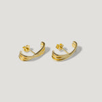 Gold wave design stud earrings on a light background