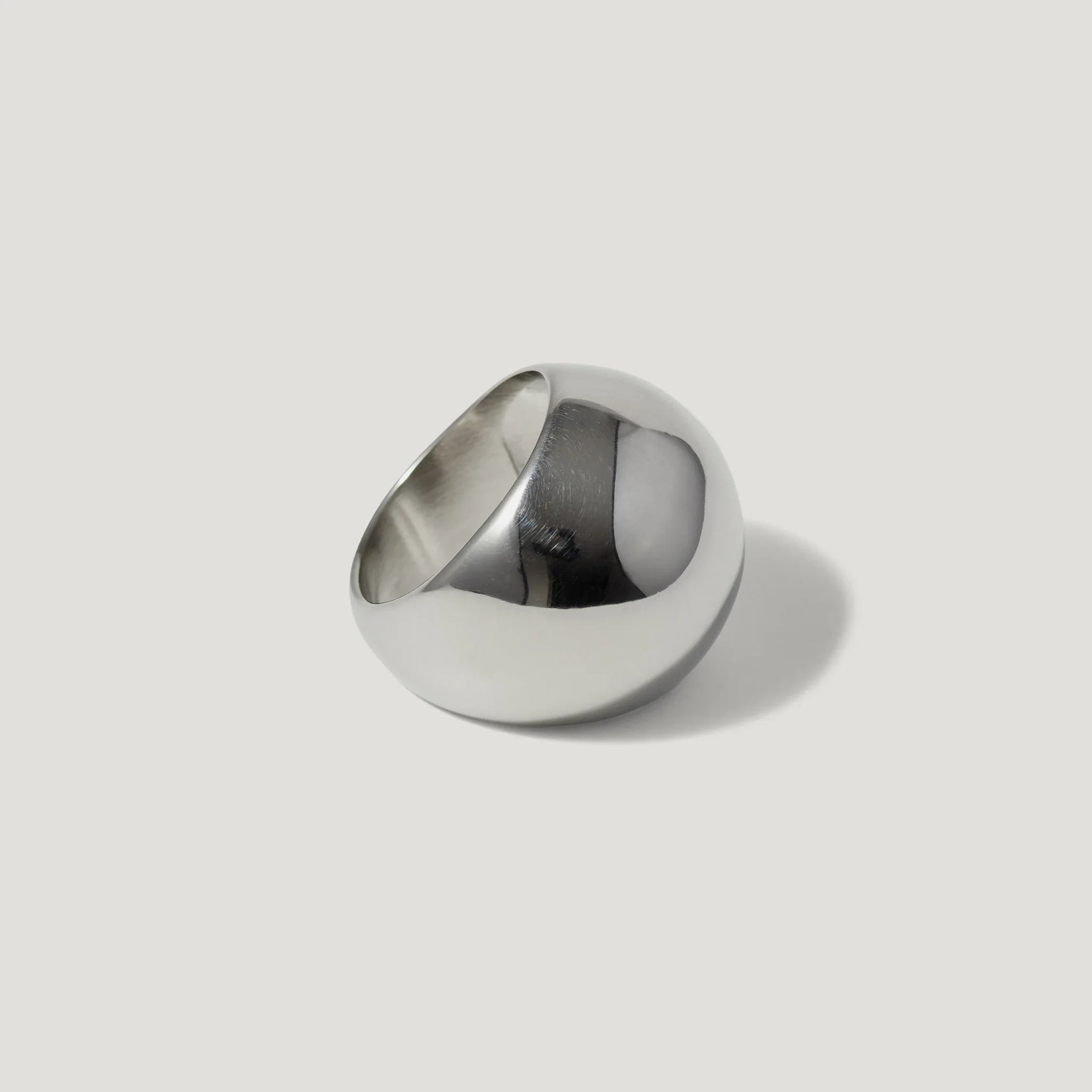 Polished silver dome ring with a modern, minimalist design on a light background