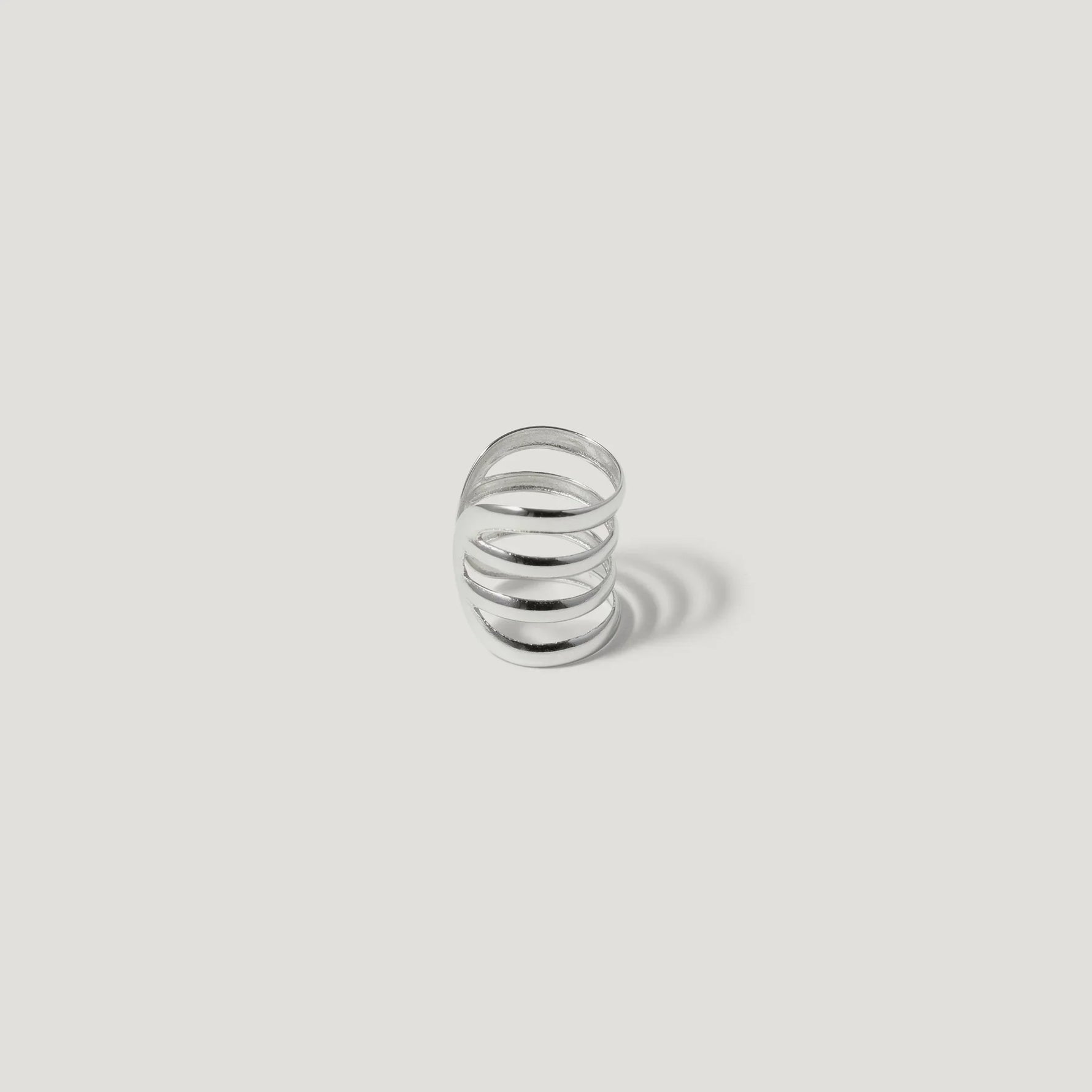 Minimalist silver spiral ring on white background, modern open band jewelry design