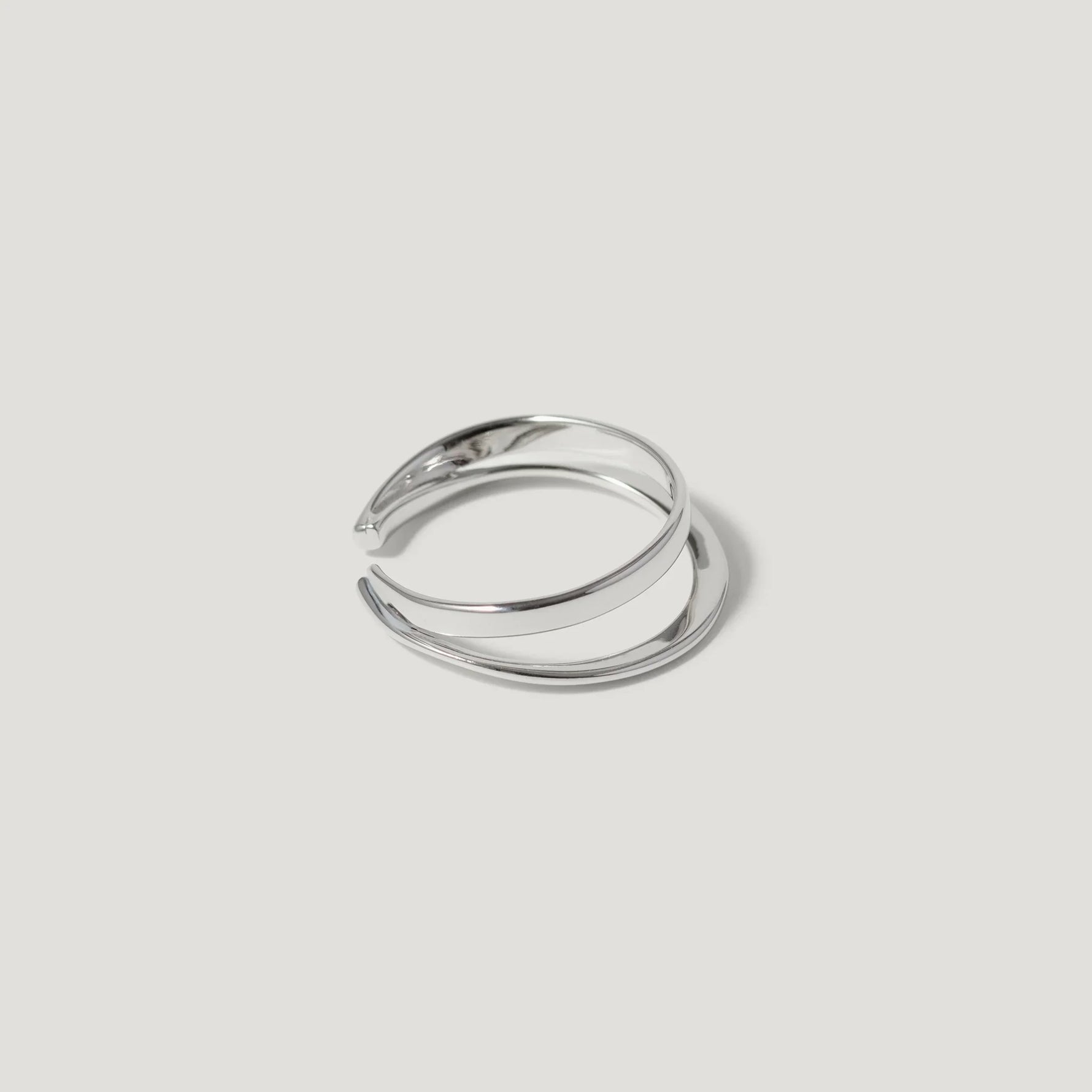 Minimalist open silver ring with double band on white background