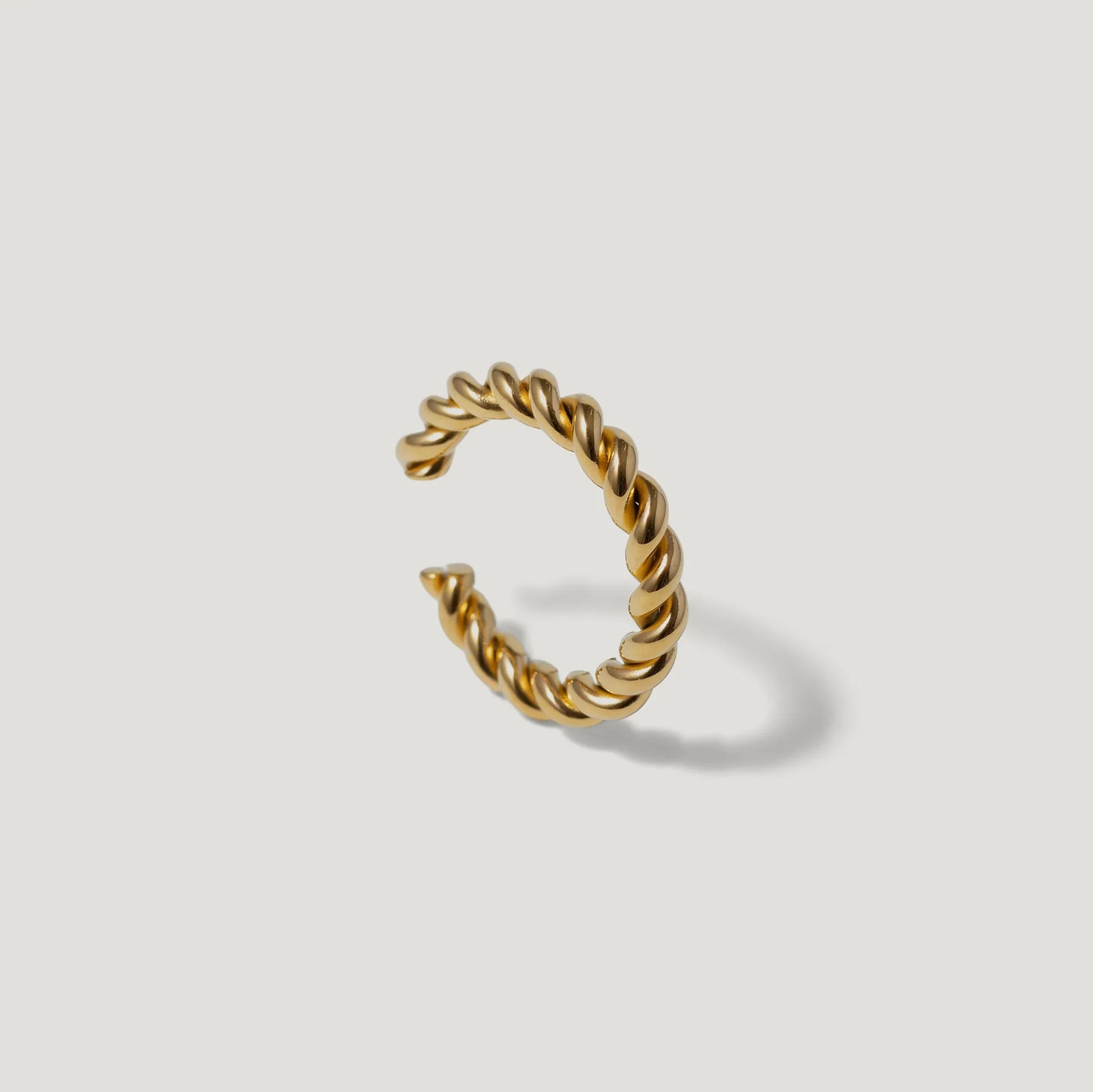 Twisted gold open ring minimalist jewelry on white background