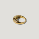 Bold gold dome ring with a smooth, polished finish on a light background