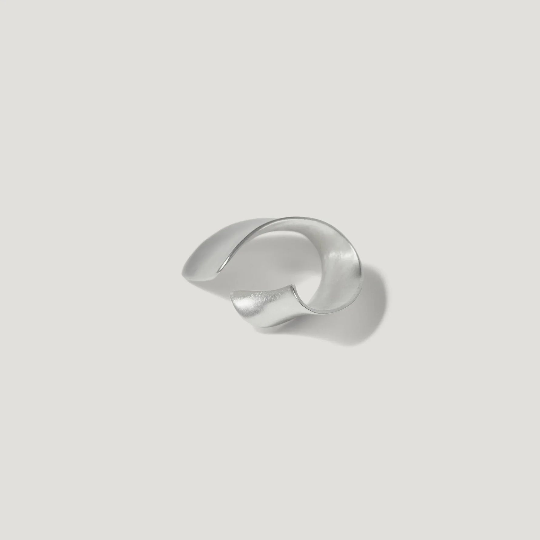 Sculptural silver cuff bracelet on a white background, modern jewelry design