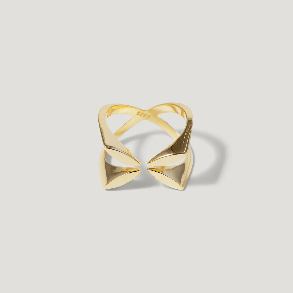 Geometric open gold ring with pointed ends on white background