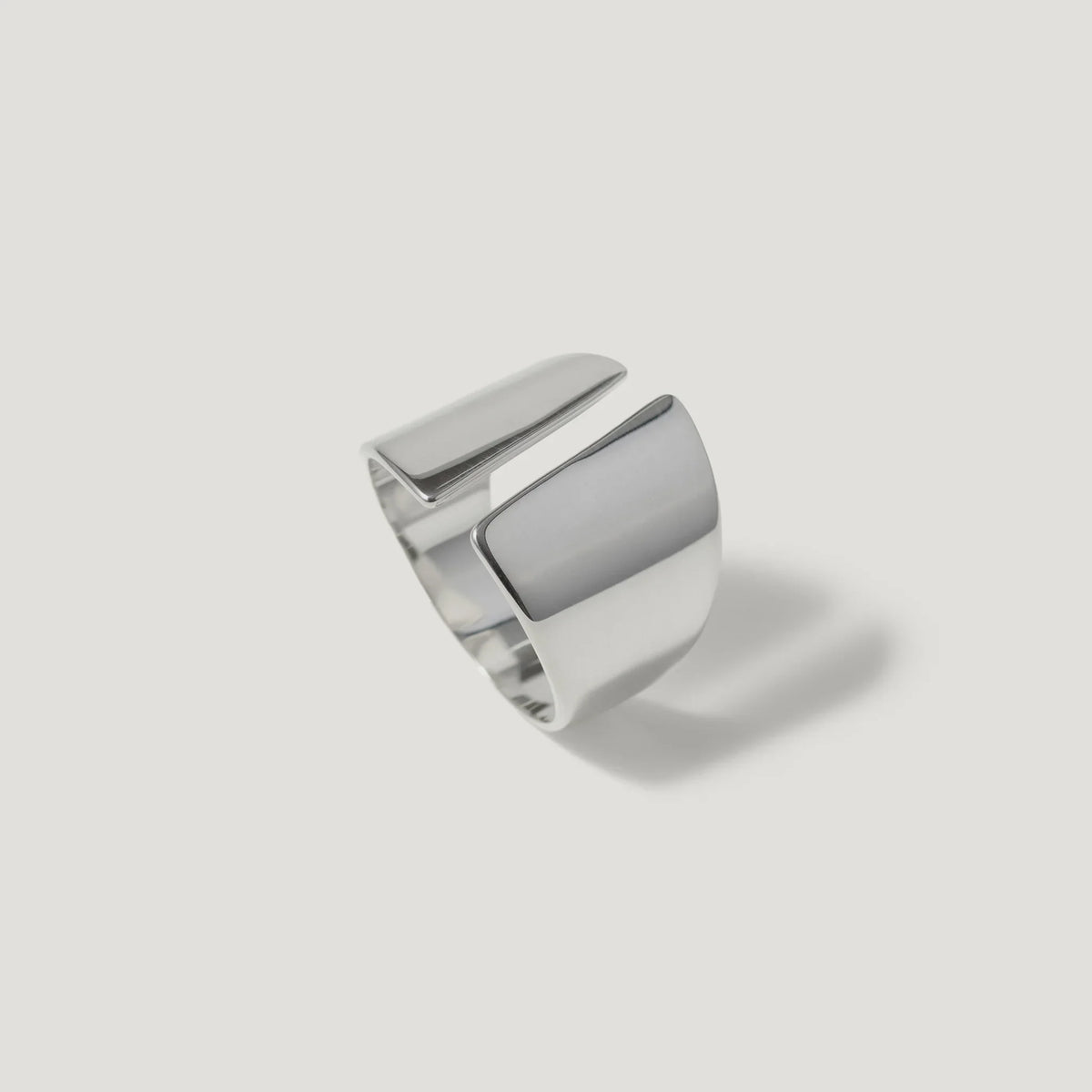 Modern open band silver ring with geometric design on white background