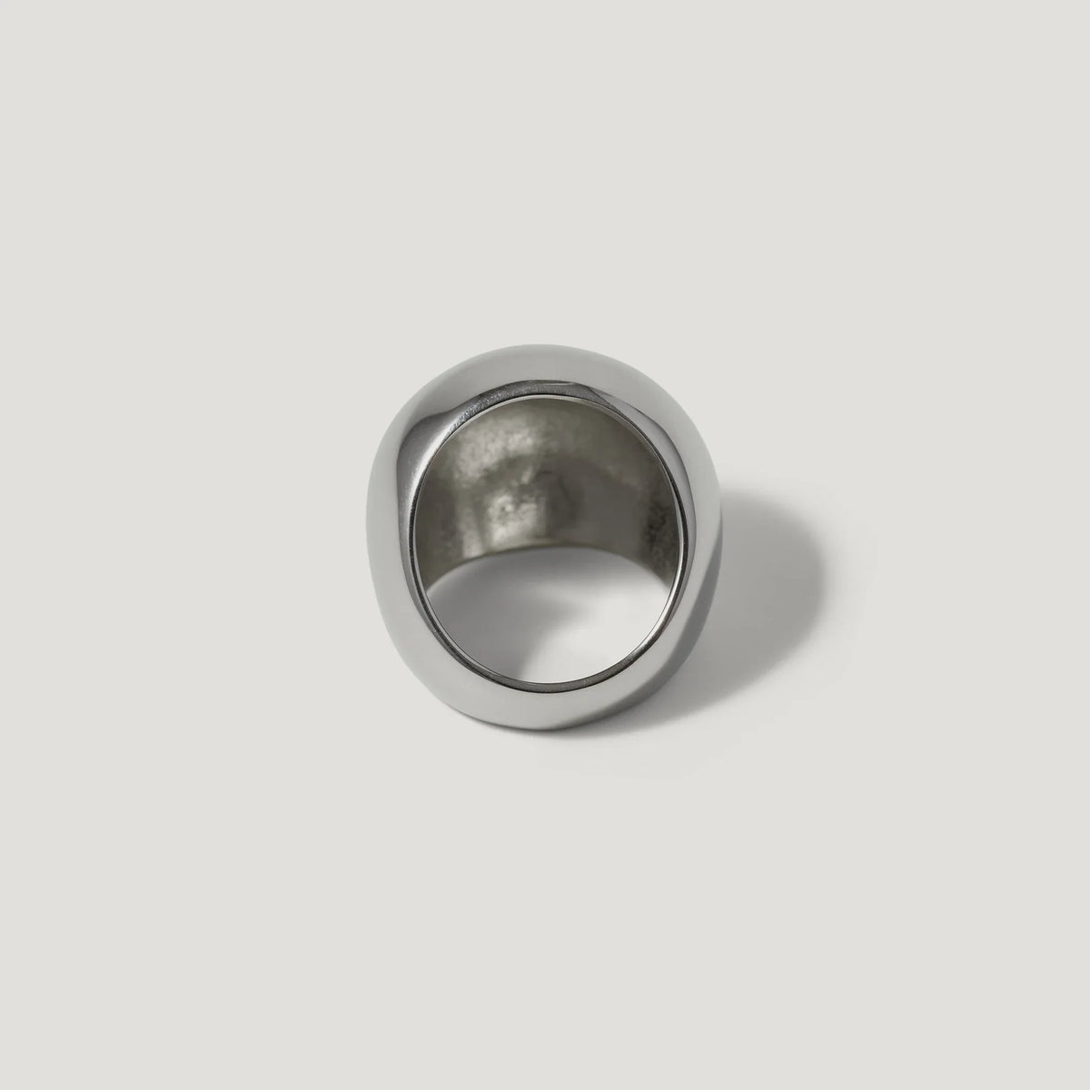 Bold silver statement ring with a wide, smooth band on a white background