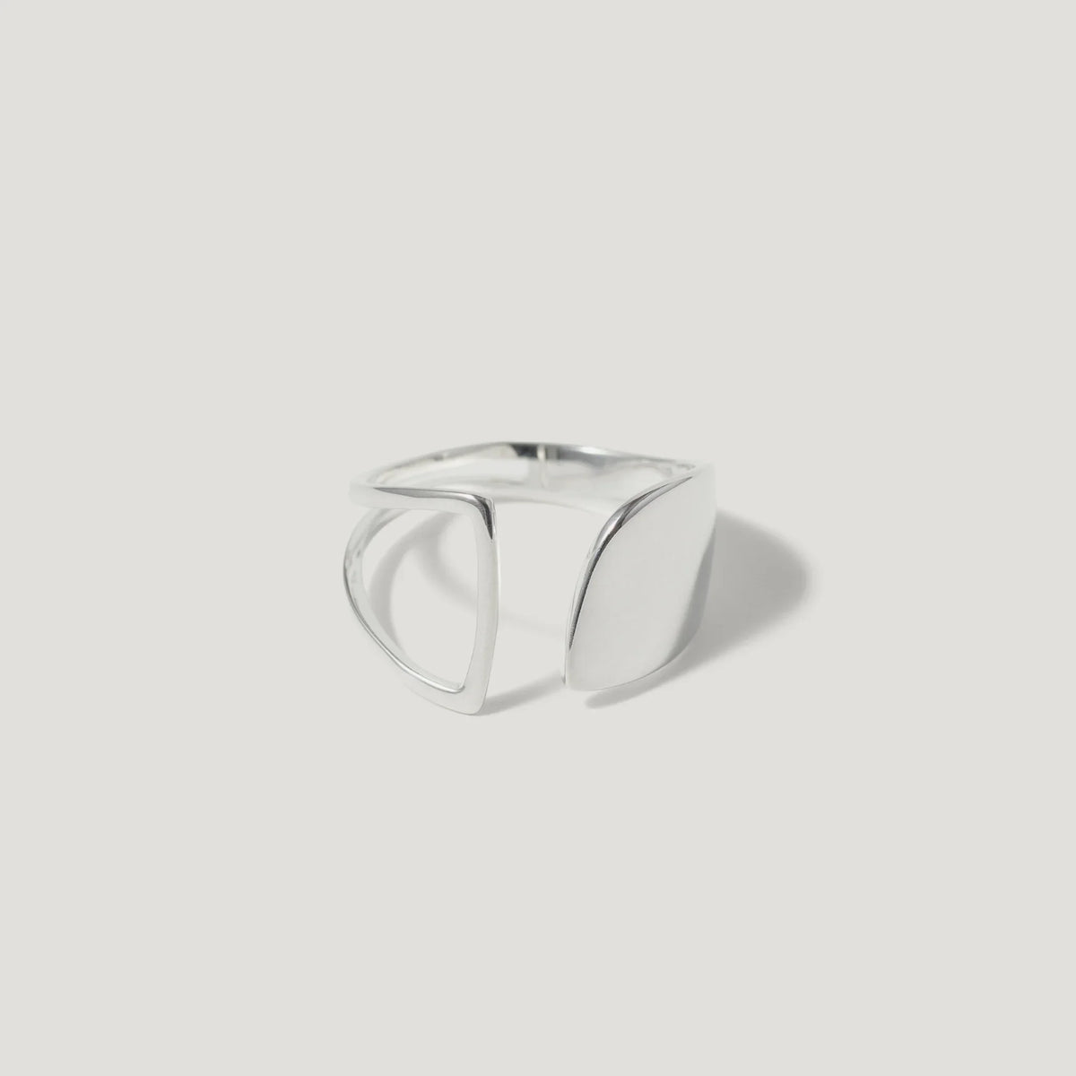 modern geometric silver ring with open design on white background