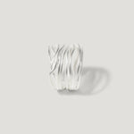 Modern sterling silver ring with layered, wavy bands on a plain light background